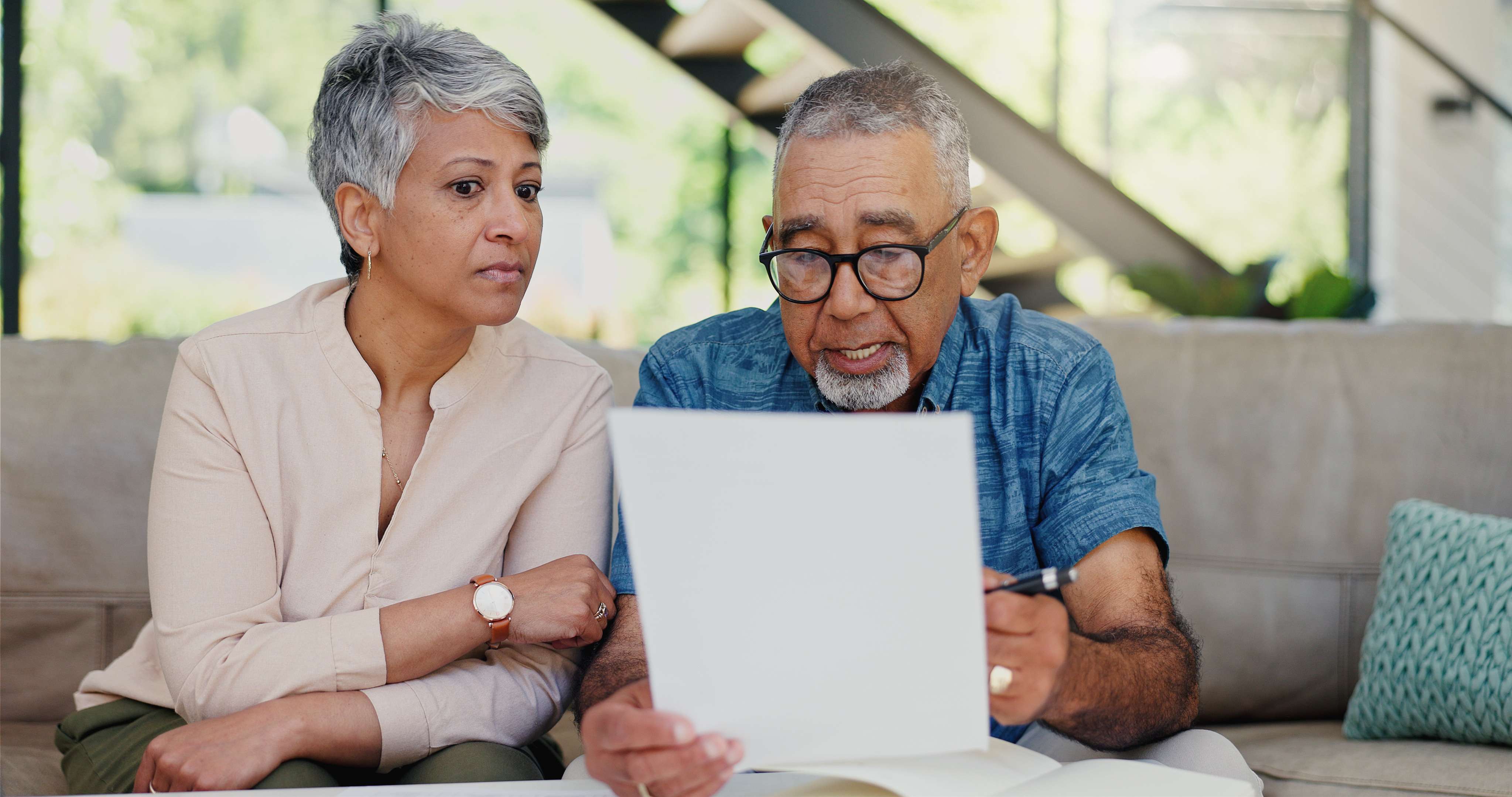 two elderly individuals reviewing a bank statement