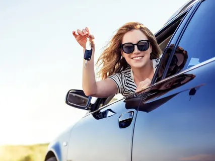 woman holding keys out car window