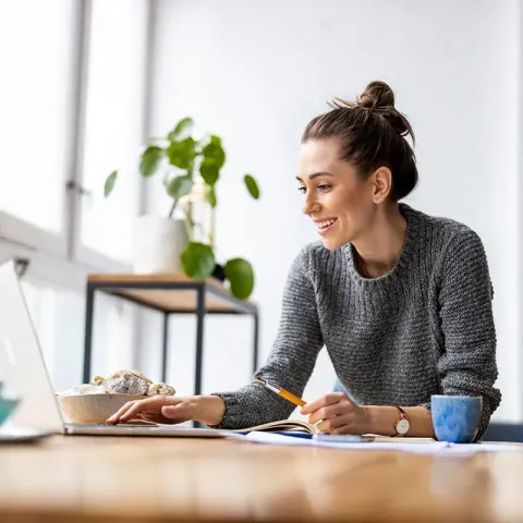 Woman on laptop with pencil